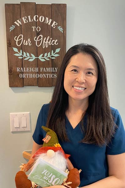 Dr. Lee holding a gift basket at Raleigh Family Orthodontics 