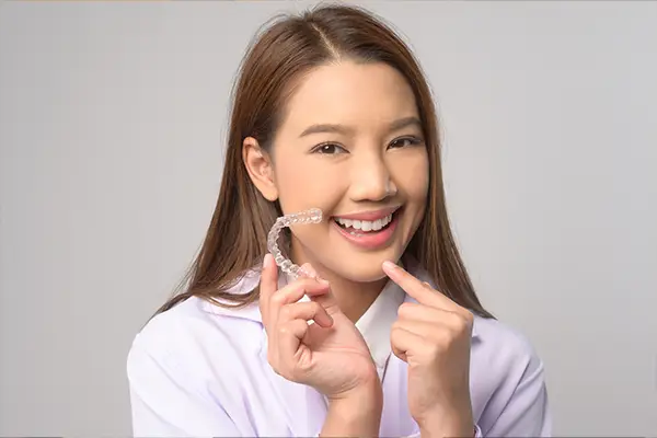 A person holding their Invisalign clear aligners