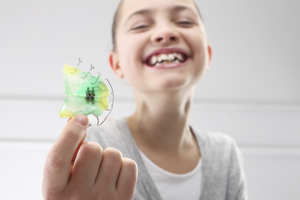 girl holding her retainer