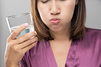 close up of woman using a salt water rinse to manage comfort during orthodontic treatment